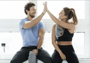 Two individuals celebrating success in the BetterTogether weight loss challenge at a gym